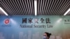 行人走过香港街头港版国安法的宣传牌。（2020年7月28日）