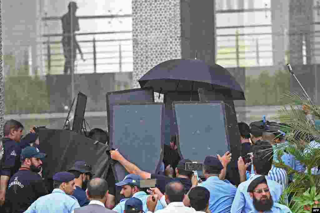 Security personnel with ballistic shields escort former Pakistan&#39;s prime minister Imran Khan, at the High Court in Islamabad.