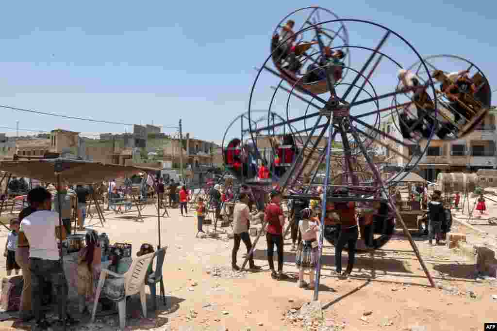 Children takes turns on an amusement ride during the first day of the Muslim feast of Eid al-Adha in Syria's rebel-held city of Binnish in the northwestern province of Idlib.