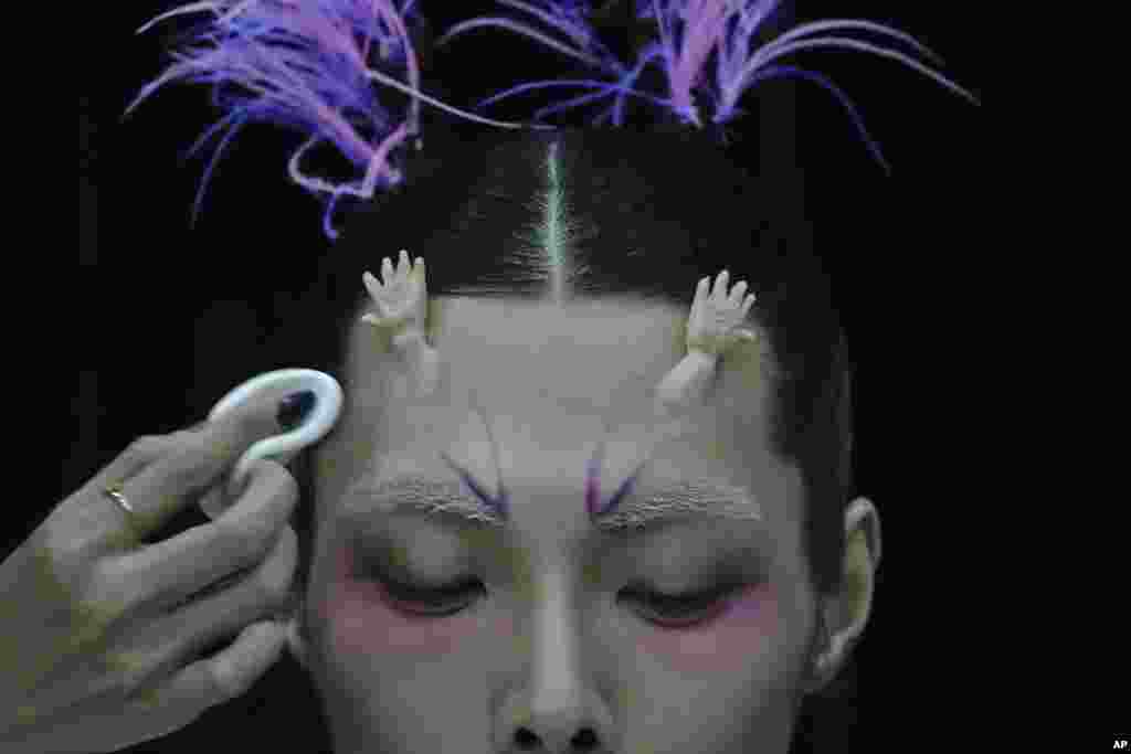 A model for the Dieyingchongchong collections by Chinese designer Dong Yaer has final makeup applied backstage during the China Fashion Week in Beijing.