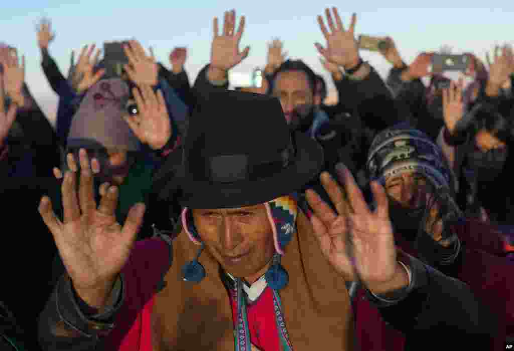Aymara Indigenous people receive the first rays of sunlight in a New Year's ritual on the sacred mountain Apacheta Murmutani on the outskirts of Hampaturi, Bolivia. Aymara Indigenous communities are celebrating the Andean new year 5,531 or "Willka Kuti," that translates to return of the sun, in Aymara.