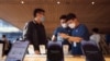 2022年9月16日，苹果新款iPhone 14在北京上市，一位顾客在苹果专卖店与销售交谈。（路透社）