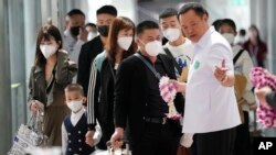 泰国卫生部长阿努廷(右 Anutin Charnvirakul）在曼谷的素万那普国际机场欢迎来自中国的乘客。（2023年1月9日）