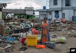 Las personas buscan en los escombros cerca de los sitios donde estaban sus casas antes del devastador tsunami en Indonesia.