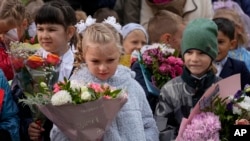 Escolares, la mayoría de ellos de primer grado, participan en una ceremonia que marca el inicio de clases en una escuela en Nakhabino, al oeste de Moscú, el 1 de septiembre.