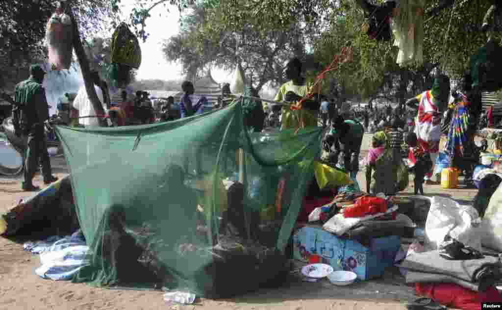 Displaced people gather under a mosquito net tent as they flee from fighting between the South Sudanese army and rebels in Bor town, 180 km (112 miles) northwest from capital Juba December 30, 2013.