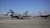 Vojni oficir prolazi između bugarskog MiG-29 i španskog aviona Eurofighter EF-2000 Typhoon II i MiG-29, u Graf Ignatievu, četvrtak, 17. februara 2022. 