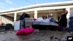 Žena posmatra svoje stvari koje je oštetila poplava izazvana uraganom Fiona, u Toa Baji, Portriko, 20. septembra 2022.