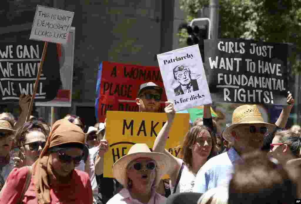 People file through the streets with placards during the Women's March against the start of Donald Trump's presidency, in Sydney, Australia, Saturday, Jan. 21, 2017. (AP Photo/Rick Rycroft)