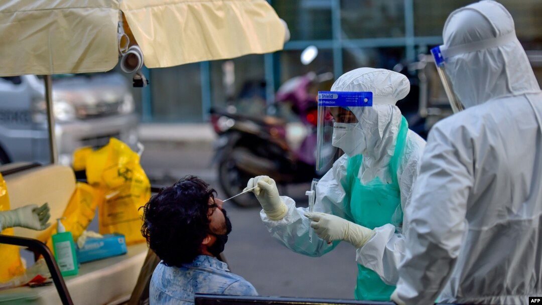 Arhiva, ilustracija - Medicinski radnici uzimaju bris za testiranje na prisustvo koronavirusa, na ulici u Maku, 5. juna 2020. (Photo by Ahmed SHURAU / AFP)