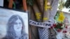 FILE: Yellow tape marks bullet holes on a tree and a portrait and flowers create a makeshift memorial, May 19, 2022, where Palestinian-American Al-Jazeera journalist Shireen Abu Akleh was killed in the West Bank city of Jenin.