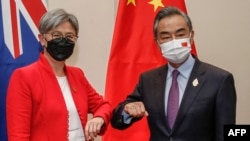 2022年7月8日，在印尼度假胜地巴厘岛努沙杜瓦举行的二十国集团外长会议期间，澳大利亚外交部长黄英贤(左)与中国外交部长王毅碰肘互致问候。（法新社）