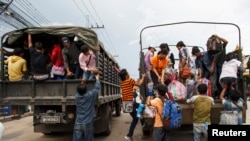 Cambodian workers ride on military trucks as they prepare to cross the Thai-Cambodia border.