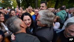 Prosvjednici ljube oporbenu kandidatkinju Jelenu Trivić tijekom prosvjeda protiv navodne izborne prijevare na općim izborima u bosanskom gradu Banja Luci, 240 km sjeverozapadno od Sarajeva, u četvrtak, 6. listopada 2022. Oporbene stranke traže otvaranje vreća i ponovno prebrojavanje glasova za predsjednik Republike Srpske. (AP Photo/Radivoje Pavičić)