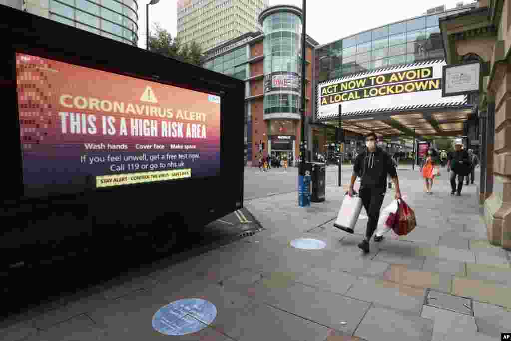 Public information messages in central Manchester England, are posted after British Prime Minister Boris Johnson set out new restrictions to last "perhaps six months" to slow the renewed spread of coronavirus.