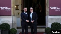 Премьер-министр Великобритании Кир Стармер пожимает руку президенту Франции Эммануэлю Макрону во время его прибытия на саммит по Украине в Ланкастер-хаус в Лондоне, 2 марта 2025 года.. 