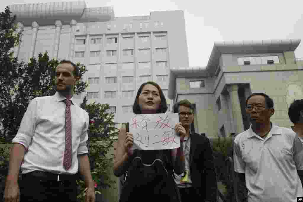 被拘押的律师王全璋的妻子李文足等人在天津第二中级人民法院门前抗议,李文足手举标语“释放刘二敏”(2016年8月1日) 。刘二敏是人权人士翟岩民的妻子,2018年4月5日和李文足一起在北京郊区游行。