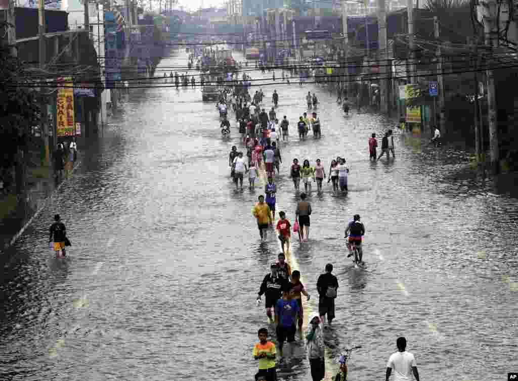 Người dân đi lại trên con đường ngập nước ở ngoại ô thành phố Pasig, phía đông Manila, 9 tháng 8, 2012.
