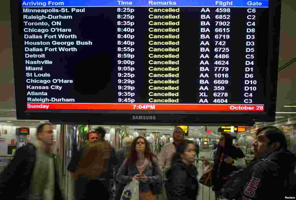 Khách đi máy bay bao quanh biển báo các chuyến bay bị hủy ở sân bay LaGuardia của New York. 28/10/2012.