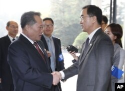South Korean Unification Minister Cho Myoung-gyon, on the right, greets his North Korean counterpart Ri Son Gwon.