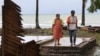 La sobreviviente del tsunami, Kusmiati, camina con su esposo Aden en una villa destruida por el tsunami en Carita, Indonesia, el miércoles 26 de diciembre de 2018. 