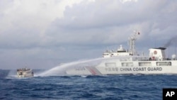 资料照片：菲律宾海警队2023年12月10日的照片显示中国海警船向菲律宾供给船发射水炮。