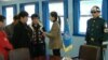 游客在非军事区停战谈判会议室内聆听导游讲解。