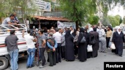 Người dân Syria chạy lánh nạn nhận khẩu phần thực phẩm của WFP phân phối tại một trung tâm phân phối thực phẩm ở Damascus,