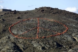 Volunteers from non-governmental organizations (NGO) arrange more than 2,500 discarded lifejackets, used by refugees and migrants, in the shape of the peace symbol on the Greek island of Lesbos, Jan. 1, 2016.