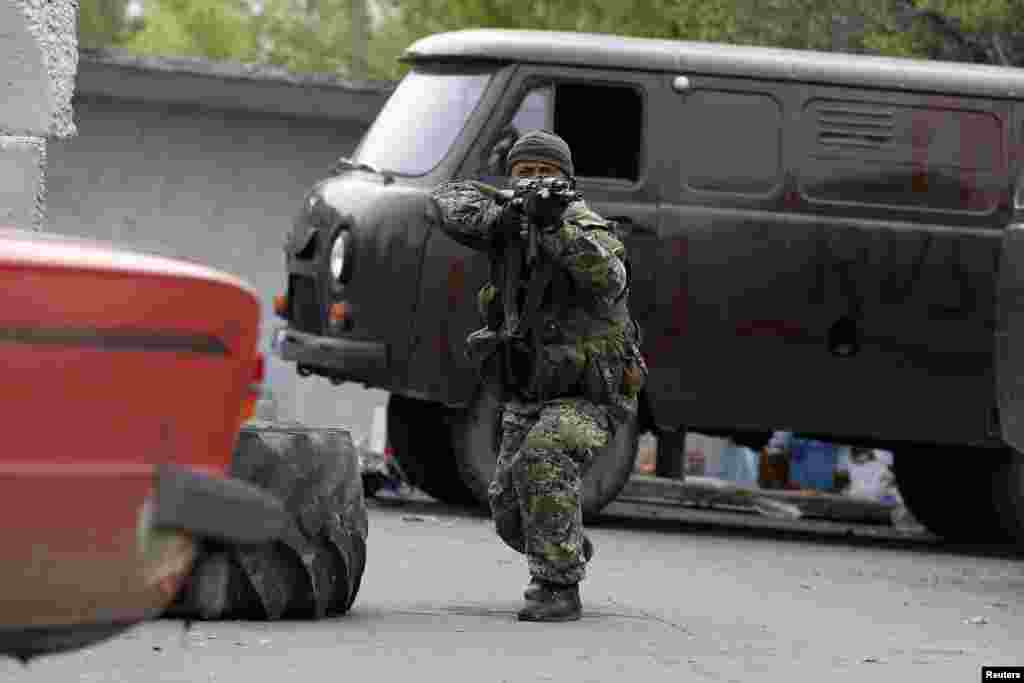 A pro-Russian rebel aims his rifle at a checkpoint near a Ukrainian airbase in Kramatorsk, eastern Ukraine, May 2, 2014.