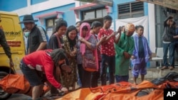 Los habitantes de la zona afectada buscan por sus familiares en los cadáveres de las víctimas del tsunami en Carita, Indonesia, el domingo 23 de diciembre del 2018. 