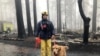 Eric Darling y su perro Wyatt son parte de un equipo del condado Orange, en el sur de California que ayuda a buscar restos en un parque de casas móviles en Paradise, California. Noviembre 23 de 2018.