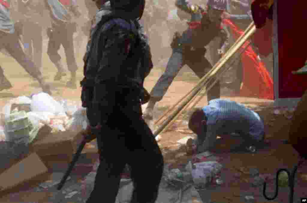 A police officer beats a student protester in Letpadan, Myanmar, March 10, 2015.