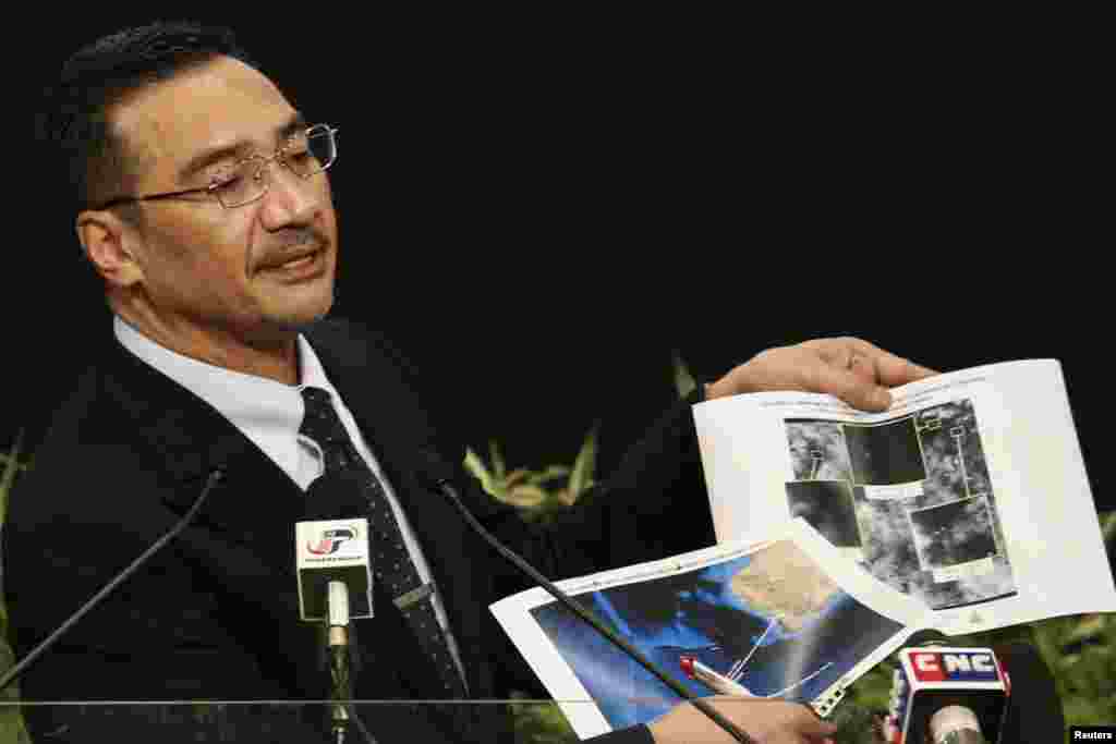 Quyền Bộ trưởng Giao thông Malaysia Hishammuddin Hussein cầm những hình ảnh vệ tinh trong cuộc họp báo về tiến trình tìm kiếm chuyến bay MH370 bị mất tích tại Trung tâm Thương mại Thế giới Putra ở Kuala Lumpur, ngày 26/3/2014.