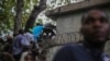 Periodistas se encaraman sobre una pared para evitar disparos de una pandilla en el Hospital General en Puerto Príncipe, el 24 de diciembre del 2024. 