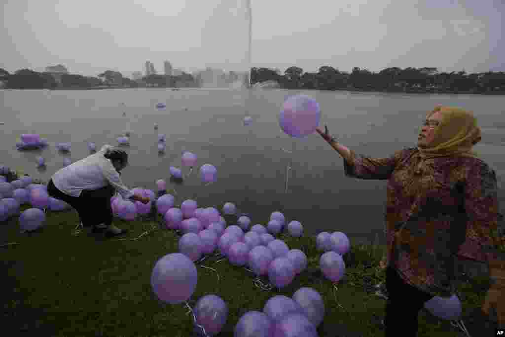 Phụ nữ Malaysia thả bong bóng tượng trưng cho những lời cầu nguyện của cho 239 người trên chuyến bay bị mất tích tại một công viên ở Kuala Lumpur, ngày 30/3/2014.