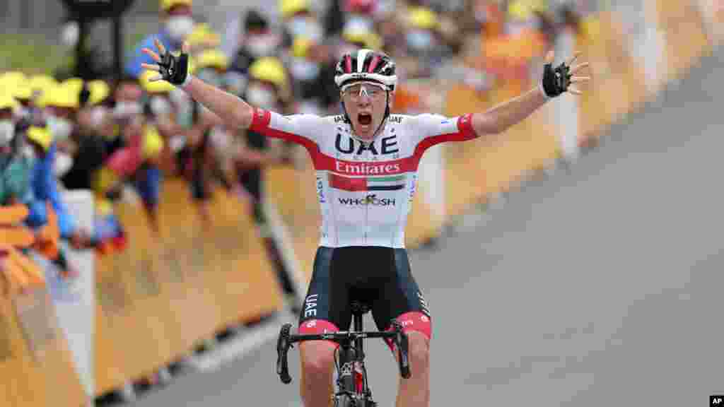 Slovenia's Tadej Pogacar crosses the finish line to win the ninth stage of the Tour de France cycling race over 153 kilometers (95 miles), with start in Pau and finish in Laruns, France.