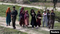 Afghan children hold the holy Koran as they go to a madrasa (religious school) in Dand Ghori district in Baghlan province, Afghanistan, March 15, 2016. 