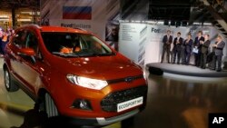FILE - Russian Prime Minister Dmitry Medvedev, second right, attends the launch of Ford EcoSport production during a visit to Ford Sollers at a plant in Naberezhnye Chelny, about 700 kilometers (450 miles) east of Moscow, Dec. 2, 2014.