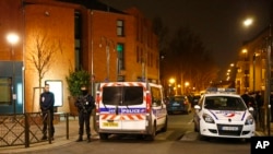 Police officers block a street in Argenteuil, northwest of Paris, late Thursday March 24, 2016 as security forces locked down the area during a major search.