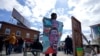 Un hombre sostiene un cartel en la Plaza George Floyd, en Minneapolis, el miércoles 21 de abril de 2021, un día después de que el exagente de policía Dereck Chauvin fuera declarado culpable por la muerte de Floyd en 2020.