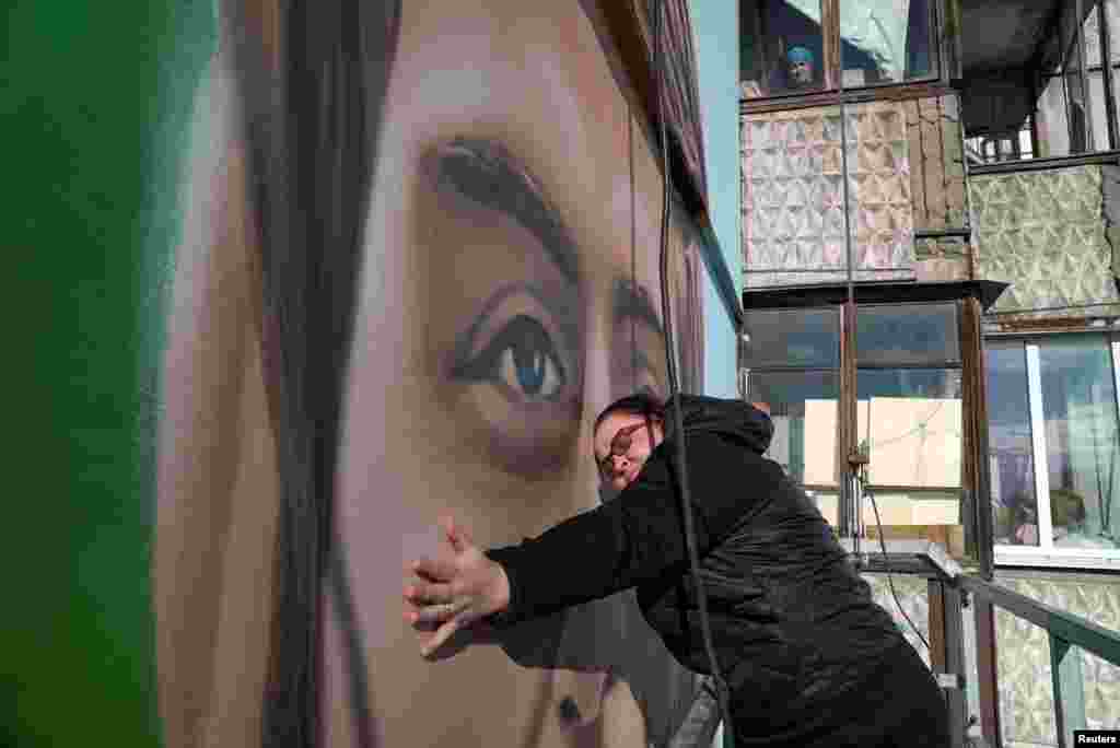 "Lo siento cada día, cada vez que paso por delante de él", dice la madre del soldado, Liudmyla Bordus, mientras acaricia la imagen pintada con aerosol en Kiev, Ucrania, el 18 de octubre de 2024. 