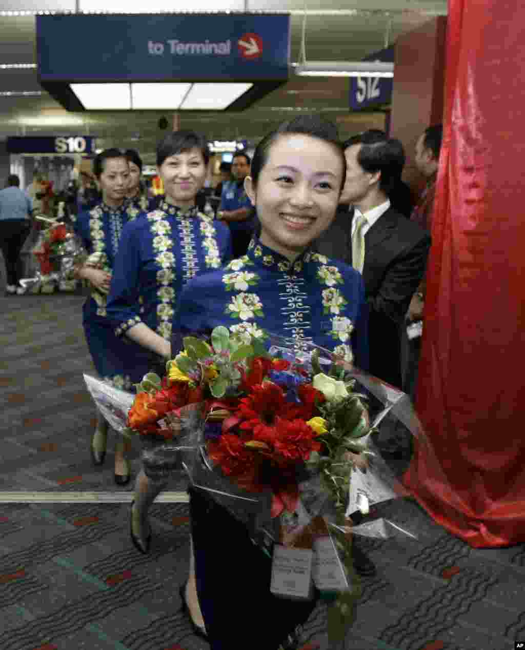2008年6月9日,海南航空公司的空姐手捧鲜花走在西雅图-塔科马国际机场。海航集团的官网表示:“截至2016年12月,海航集团拥有飞机逾1250架,旗下航空运输企业开通国内外航线近1100条,通航城市270余个,年旅客运输量逾9200万人次。运营管理海南航空、天津航空、首都航空、金鹿公务、祥鹏航空、西部航空、福州航空、乌鲁木齐航空、北部湾航空、扬子江航空、桂林航空、长安航空、加纳AWA航空、法国蓝鹰航空等航空公司。”