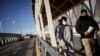 Un migrante es escoltado por un agente del Instituto Nacional de Migración (INM) de México, luego de ser deportado de Estados Unidos, en Ciudad Juárez.