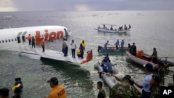 Cảnh cảnh sát và nhân viên cứu hộ dùng xuồng cứu sinh sơ tán hành khách trên chiếc máy bay Boeing 737, do hãng hàng không giá rẻ Lion Air điều hành, ngày 13/4/2013. 