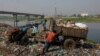 Trabajadores arrojan desechos junto al río Dhaleshwari, cuya agua fluye hacia el río Buriganga, en Savar, Bangladesh, el 7 de marzo de 2023. El Buriganga -o Viejo Ganges- está tan contaminado que su agua aparece completamente negra y emite un hedor fétido durante todo el año.
