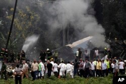 El presidente de Cuba, Miguel Diaz-Canel, tercero desde la izquierda, se aleja de un campo de yuca donde cayó un Boeing 737 con más de 100 personas a bordo. Habana, Cuba. Mayo 18, 2018.