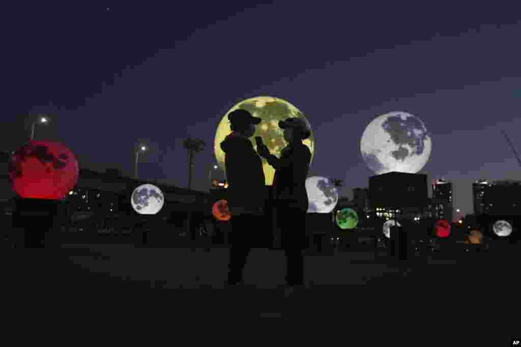 Women stand next to glowing full moon installations at a park in Seoul, South Korea. The artificial full moons were installed to increase morale during COVID-19 and to celebrate the upcoming Chuseok holiday, the Korean version of Thanksgiving Day.
