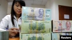 Nhân viên đếm tiền tại quầy của Ngân hàng Quốc tế Việt Nam ở Hà Nội.