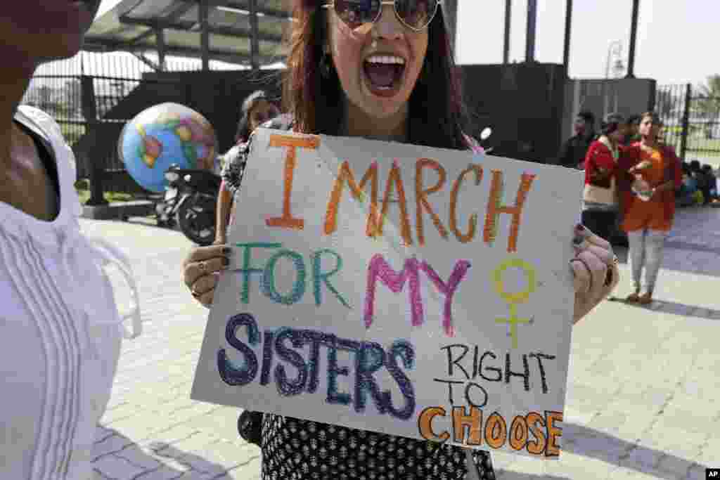 Activist Sarah Annay Williamson holds a placard and shouts slogan during the Women's March rally in Kolkata, India, Jan. 21, 2017. (AP Photo/Bikas Das)